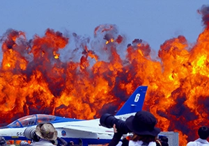 ブルーインパルスが駐機している滑走路の奥で爆炎が上がる