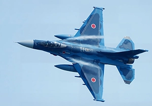 鮮やかなブルーのF-2戦闘機がバンクして旋回する