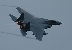 両翼の先端からベイパーを引くF-15